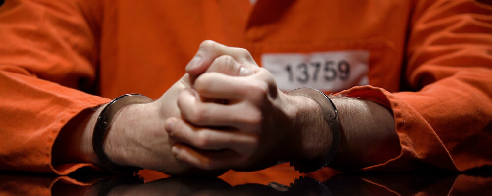 man in orange jumpsuit with handcuffs