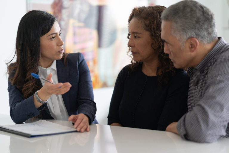 Couple talking to an attorney to discuss their insurance settlement