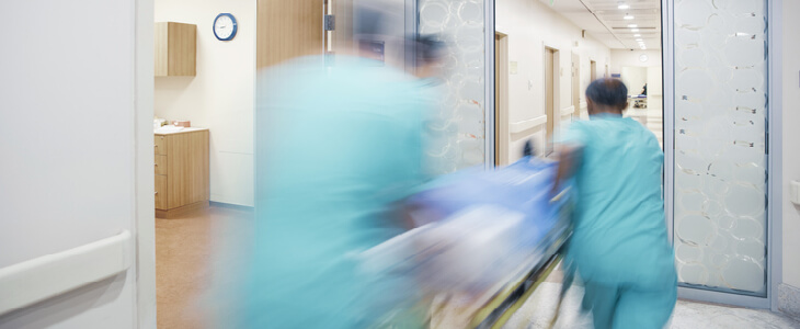 emergency medical professional in a hospital rushing a patient on a gurney