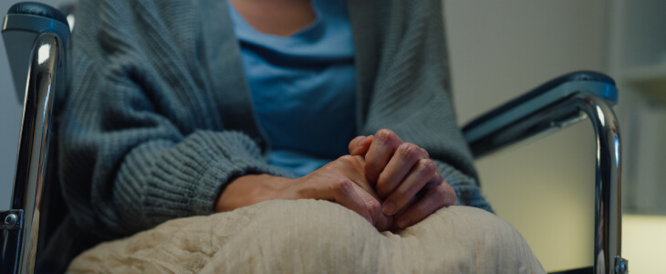 Nursing home patient with hands folded in lap