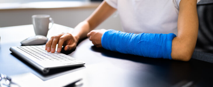 Broken Arm African Woman On Computer